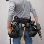 Homme de dos qui porte une ceinture d'outils de bricolage